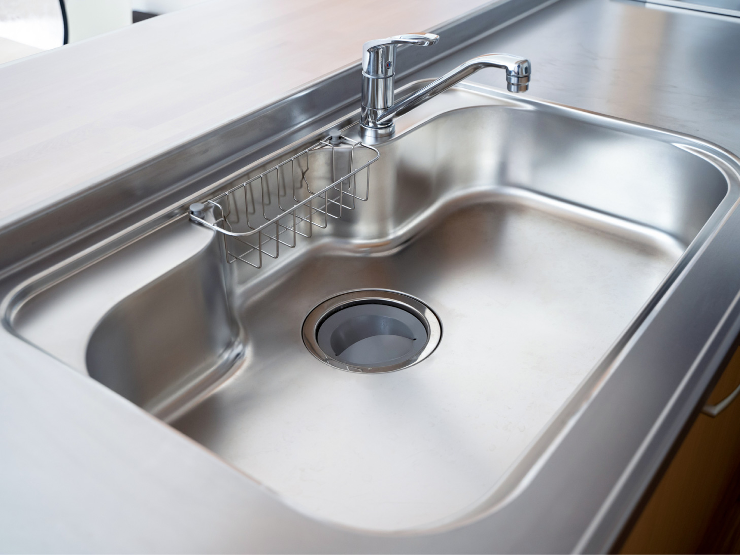 従来のキッチンシンクでは、スポンジや洗剤の収納スペースがない